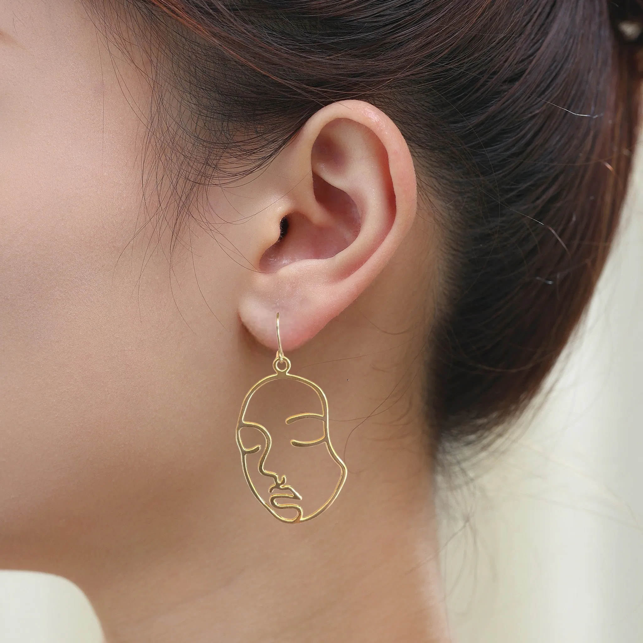 Golden face drop earrings